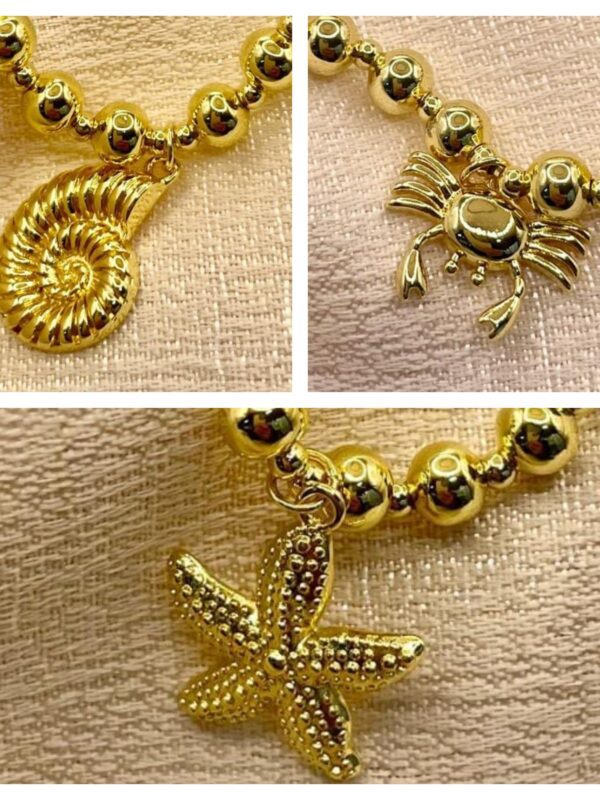 2025/08/1001540516-scaled.jpg pulsera marinas billa caracol, cangrejo, estrella de mar dorado