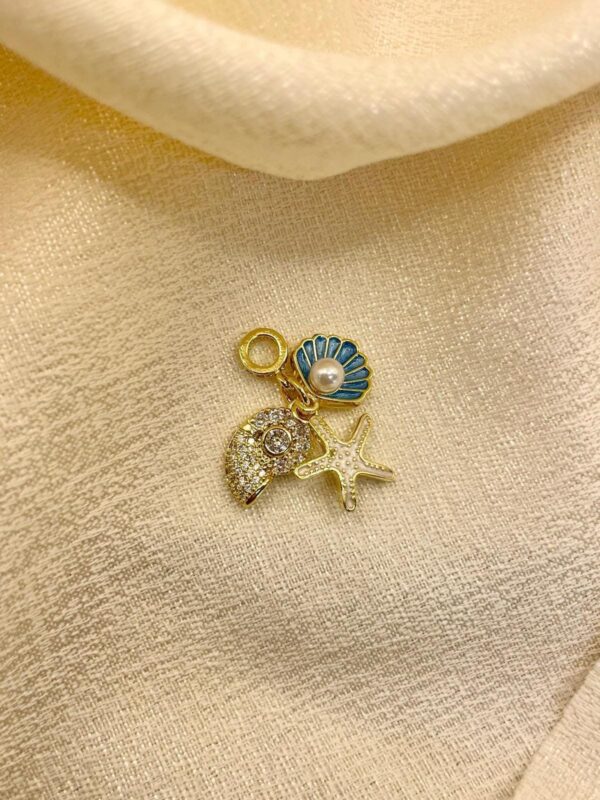 2025/08/IMG-20250819-WA0036.jpg Dije Charm marino estrella caracol concha dorado