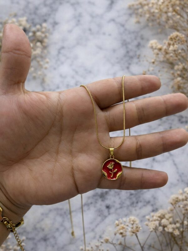 WhatsApp Image 2026-02-18 at 10.34.19 AM (1) collar flor fondo rojo acero dorado