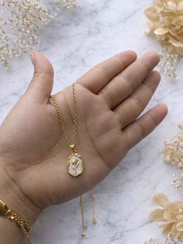 WhatsApp Image 2026-02-18 at 10.34.19 AM collar flor fondo blanco acero dorado